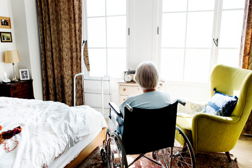 Woman in nursing home looking out window