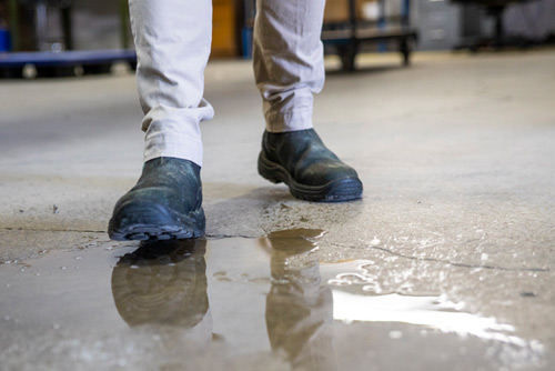 person walking on wet cement